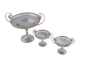 A George V sterling silver garniture comprising a two handled pierced circular comport (21cm diameter), and a pair of smaller (10cm diameter) matching comports, by Martin Hall & Co. Ltd., Sheffield, circa 1923, 21cm and 11cm high, 740 grams, (3 items).