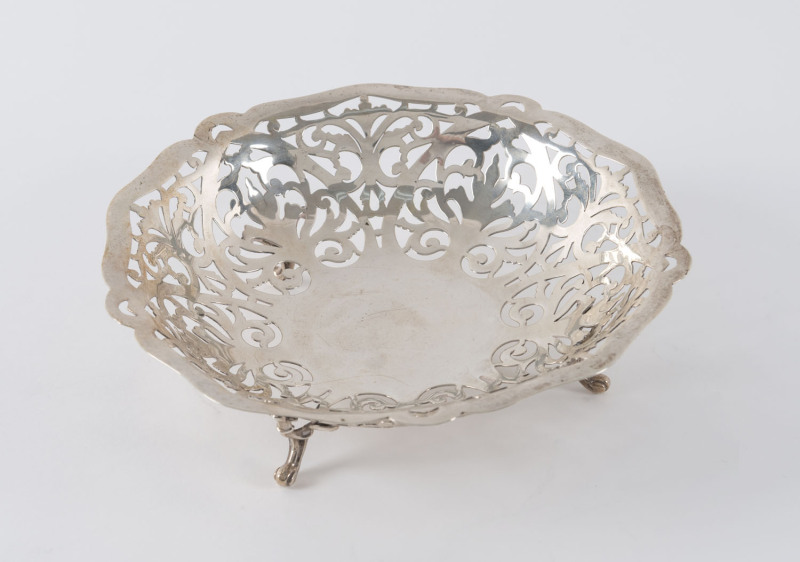 An Edwardian sterling silver circular pierced bowl on three scroll feet, Birmingham, circa 1902, ​18cm diameter, 200 grams.