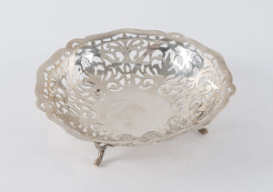 An Edwardian sterling silver circular pierced bowl on three scroll feet, Birmingham, circa 1902, 18cm diameter, 200 grams.