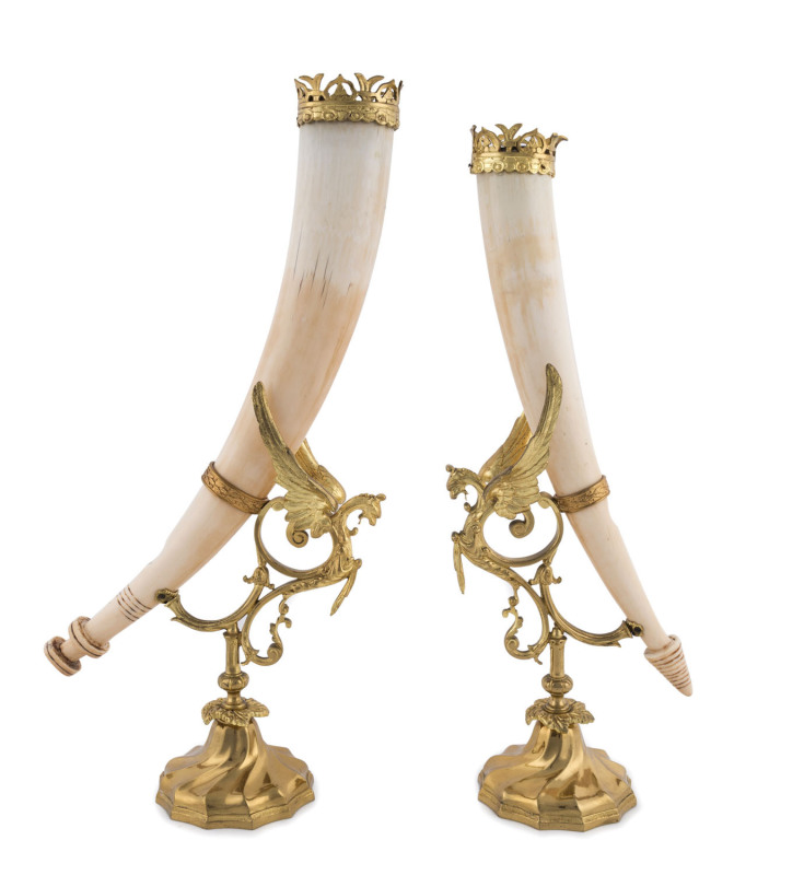 A pair of unusual tribal horns, carved ivory with French ormolu mounts decorated with griffins, 19th century, ​52cm high