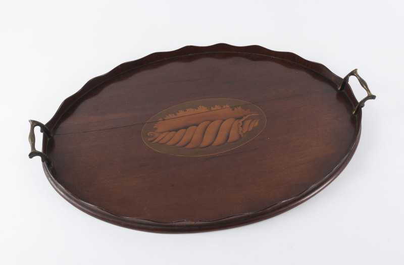 A Georgian oval serving tray, mahogany with marquetry conch shell decoration, serpentine gallery and brass handles, circa 1810, ​59cm across the handles,