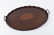 A Georgian oval serving tray, mahogany with marquetry conch shell decoration, serpentine gallery and brass handles, circa 1810, ​59cm across the handles,