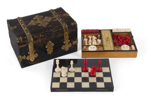 An impressive antique games box, coromandel and satinwood with brass fittings. Interior fitted with compartments, lift out tray and double-sided games board. Includes a fine array of carved bone and ivory gaming pieces comprising chess, draughts and backg