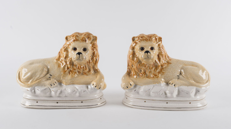 A pair of Staffordshire porcelain recumbent lions, mid 19th century, ​20cm high