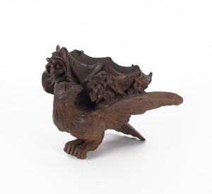A Black Forest carved hanging candle holder in the form of a bird, 19th century, 31cm long