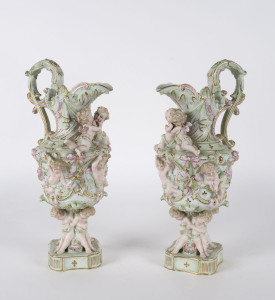 A pair of German bisque porcelain ewers decorated with applied cherubs, 19th century, 33cm high