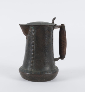 An English Arts and Crafts water jug, hand beaten copper finish with wooden handle, late 19th century, 19cm high