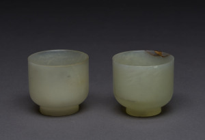 A pair of jade teacups, one with antique gold filled restoration, 18th/19th century, 6cm high