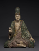 A Chinese statue of a seated scholar, carved wood and polychrome finish, Qing Dynasty, 47cm high