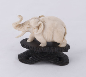 A Chinese carved ivory elephant statue on carved wooden stand, late 19th early 20th century, ​7cm high overall