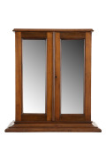 A small mirrored two door cabinet, interior fitted with drawers and pigeon holes, walnut, circa 1885, 57cm high, 53cm wide, 28cm deep