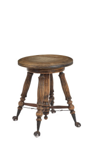 An American revolving piano stool, carved walnut with iron claw feet clutching glass pads, circa 1895, 45cm high