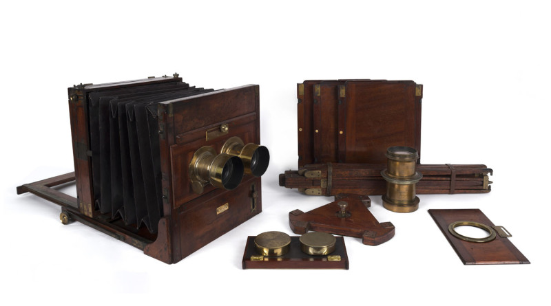 W. WATSON & SONS: circa 1880-1890 mahogany & brass wet/dry Tropical Tailboard stereo camera, with double extension burgundy leather bellows. The pair of lenses are by Negretti & Zambra of London and there is also a single Lancaster & Sons 15 x 12 Rectigra