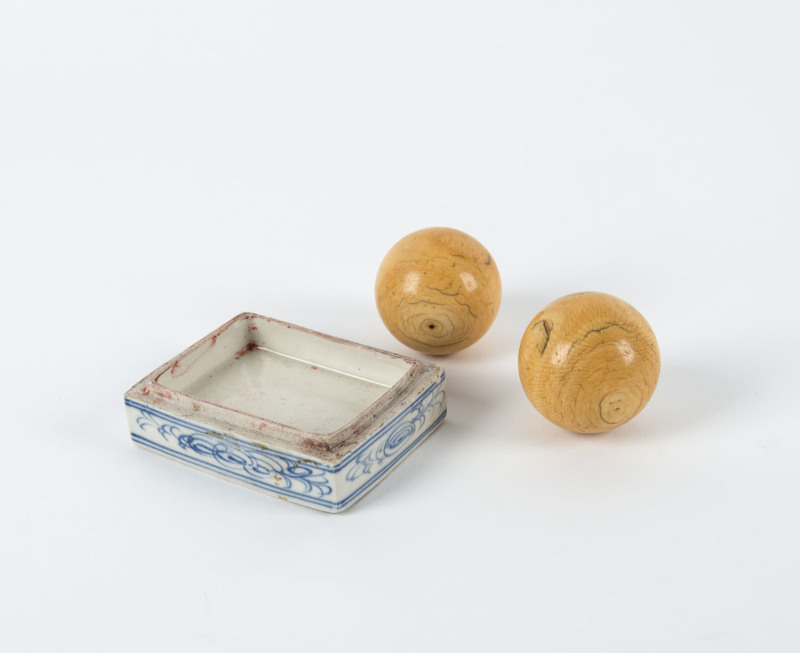 Two antique ivory billiard balls and an antique Chinese porcelain dish base, 19th century, the dish 9.5cm across