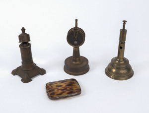 Two brass table cigar cutters, a table cigar lighter and a cigarette case, early 20th century, ​the tallest 16.5cm high