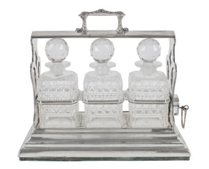 An English silver plated three bottle tantalus set with signature plaque "Dr Frank Hartnett", 19th century, ​37cm high