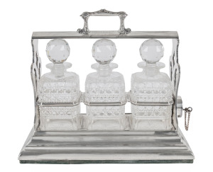 An English silver plated three bottle tantalus set with signature plaque "Dr Frank Hartnett", 19th century, 37cm high