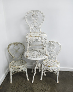 A Coalbrookdale style garden table and three chairs, white painted cast iron, 19th century, the table 66cm high, 53cm diameter