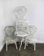 A Coalbrookdale style garden table and three chairs, white painted cast iron, 19th century, the table 66cm high, 53cm diameter