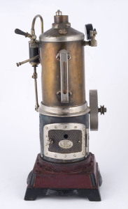 c.1915 Doll & Co vertical boiler & inverted steam engine, boiler with lower fire door, water gauge, flywheel and safety valve, mounted on cast-iron base painted in deep red, maker's plate on the fire door, detachable chimney is missing, base 11x11cm, height 25cm, weight 1.15kg.