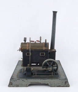 1930s Marklin composite steam toy comprising brass boiler with pressure gauge, pressed tin boiler house, engine with 8cm diameter flywheel, Marklin name plate on the boiler door, all mounted on 30cm square cast metal base, height 36cm, weight 1.85kg