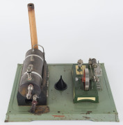 1960s Fleischmann composite steam toy comprising brass boiler mounted on pressed tin boiler house, engine with 7cm diameter flywheel, ladder & platform, all mounted on 34x26cm cast metal base, height 26cm, weight 1.56kg