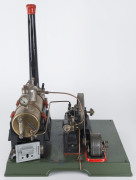 1930s Marklin composite steam plant, comprising horizontal 7cm diameter brass boiler with manometer above boiler house, engine with 12cm flywheel connected to a dynamo, Marklin name plate on dynamo and impressed on the boiler door, mounted on a 34x27½cm c