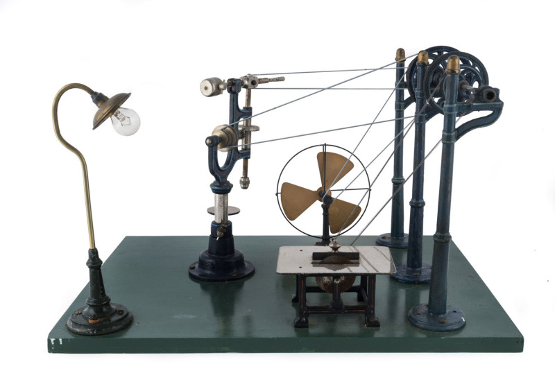 1930s Marklin (?) steam powered workshop with pulley system mounted on three cast iron masts relaying power to a circular saw, hammer, fan and lamp, all affixed to a wooden base (44x32½cm), height 28cm, weight 3.90kg. (please note this a workshop only, no