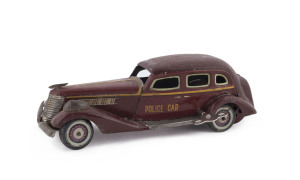 1930's Graham Paige wind-up four-door sedan in red, marked "POLICE CAR" on both front doors; by Kuramochi. Length: 28cm (11").