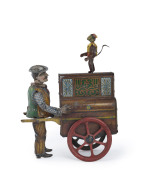 JACKO THE MERRY ORGAN GRINDER AND MONKEY by Distler, Germany, 1920s. Lithographed tin street-organ with spoked wheels, pushed by gaudily dressed gypsy; a monkey standing atop the organ. When wound, the man winds the organ which moves forward, the monkey 