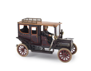 CARRETTE LIMOUSINE Germany, handpainted example from the early 1910s, a finely detailed example, done in rich dark colours accented by orange roof and trim work, nickel hood appointments, spoke wheels, rubber tires, seated driver, clockwork driven. Length: 23cm (9"). Provenance: The Donald Kaufman Collection - Sale III - April 2010 - Lot 3155.