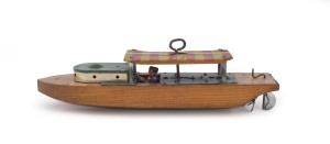 Cabin cruiser river boat, made by Liberty Playthings Company of Niagara Falls, New York, circa 1920s with a wooden hull, a lithographed tinplate canopy and a wind-up clockwork motor with the tin lithographed driver still in place. Length: 25.5cm (10").