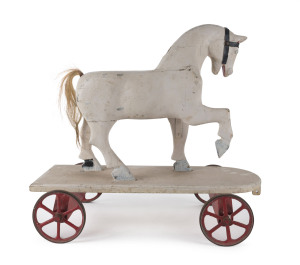 A pull along horse toy, painted and carved wood with horse hair tail and iron wheels, early 20th century, 54cm high