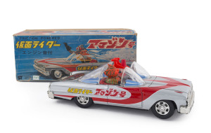 MASKED KAMEN RIDER in Ford Galaxy Tin-plate friction-powered car by AOSHIN TIN TOYS, Japan, circa 1970; in original box. Friction drive produces distinctive LOUD clicking noise. Length: 25cm (10"). Rare in this condition and with box.