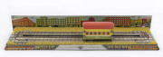 Tin-plate lithographed wind-up trolley car on track with city-scape backdrop; by Modern Toys / Masudaya, 1950s. Length (of track): 23.5cm (9.25").