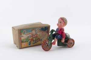 "CIRCUS TRICYCLE" celluloid boy riding a windup tinplate tricycle (green) with colourful metal wheels and a bell; the boy marked "Made in Japan" circa 1948, the box with Yonezawa trademark "Y". In original box. Length: 12cm (4.75").