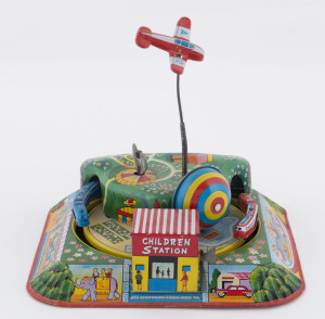 VACATION EXPRESS windup tinplate lithographed toy, by YONEZAWA, with an aeroplane circling overhead and two trains circling a funfair scene; internal key. Circa 1960. Size: 14cm square (5.5").