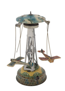Vintage tin plate lithographed windup carousel with two (of three) aeroplanes rotating around a central tower; one with "SPEED" and the other with "SWALLOW" on the wings; one with "Made in Japan" on the fuselage. The top features biplanes and a zeppelin. 