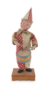 Wind-up drummer boy dressed as a clown with original outfit, celluloid head and arms, standing on a wooden base which is stamped "MADE IN JAPAN" underneath. Height: 30cm (12").