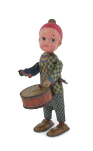 Vintage drummer boy with celluloid head, tinplate lithographed outfit and drum, integrated wind-up key. Arms and head move when wound. Height: 21cm (8.25").