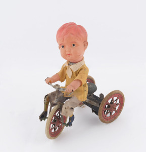 Vintage tinplate boy on tricycle, celluloid head and arms, wind-up mechanism, original clothing, rubber types marked "Made in Japan". Height: 21.5cm (*.5").