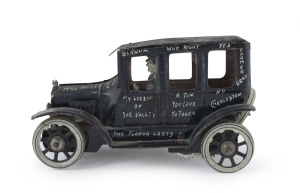 Graffiti-covered Honey Mooners four-door tinplate wind-up saloon with uniformed driver, by Marx (?) circa 1920s. "I Love You - 4 Wheels No Brakes". Spare wheel at rear. Length: 18cm (7").