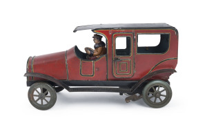 LARGE WIND-UP LIMOUSINE, Germany circa 1920s (by Gunthermann?), lithographed tinplate, with red body, black roof and full running boards, features a driver in a warm jacket and cap; two opening doors. Length: 25cm (10").