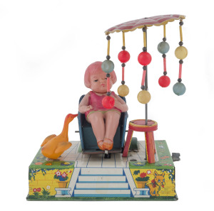 "HAPPY LIFE" tin-plate and celluloid wind-up toy by Alps / Kuramochi; with a rotating umbrella, a rocking sun-bather and a happy duck sitting on a highly decorated lithographed platform. Height: 20cm (8").