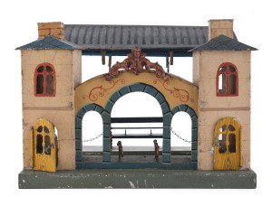 BING (attributed) "O" Gauge railway station in painted or lithgraphed metal, with ornate entrance gate building plus canopied platform with double-facing seat; two operable doors, removable roof components. Width: 27cm (10.5"), Height: 19cm (7.5"). German