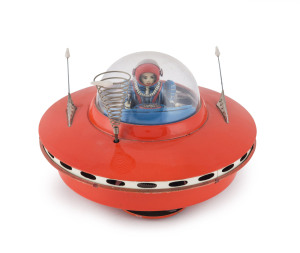 YOSHIYA SKY PATROL FLYING SAUCER circa 1965When it hits an object, the beautifully lithographed female astronaut/pilot moves the levers and steers her flying saucer in a new direction. "K.O." in a diamond trademark on the back of the seat. Battery operated. Width: 20cm (8").