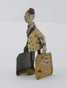 Clockwork lithographed tin-plate wind-up bell-hop boy with two suitcases and a red cap. Height: 19cm (7.5"). - 2