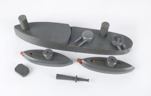 Scratch built "exploding" wooden battleship made up of nine parts, plus two submarines with wooden torpedoes, two target points on the battleship triggering the mouse-trap mechanism when hit by the torpedoes, circa 1920s. Length 38cm (14.75"), width 8cm (