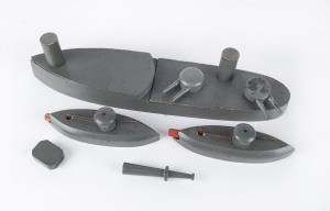 Scratch built "exploding" wooden battleship made up of nine parts, plus two submarines with wooden torpedoes, two target points on the battleship triggering the mouse-trap mechanism when hit by the torpedoes, circa 1920s. Length 38cm (14.75"), width 8cm (3.2"); submarines length 16cm (6½"); width 5cm (2").