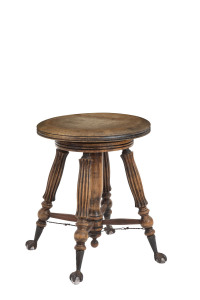 An American revolving piano stool, carved walnut with iron claw feet clutching glass pads, circa 1895, ​45cm high